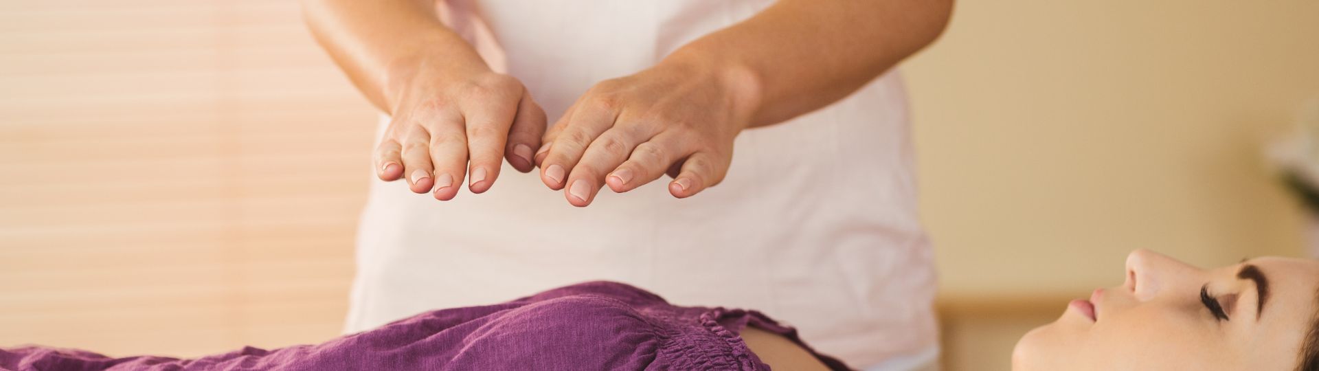 Hands performing energy healing during Reiki training, representing the power of touch for natural healing.