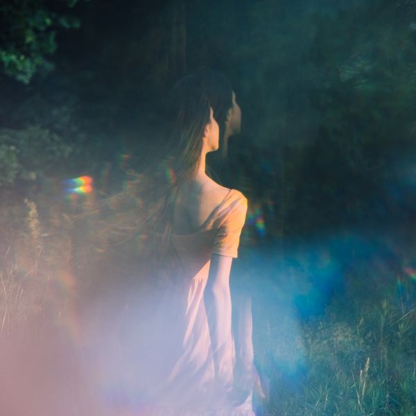 Double exposure of a woman in meditation surrounded by nature, symbolizing deep spiritual connection and introspection.